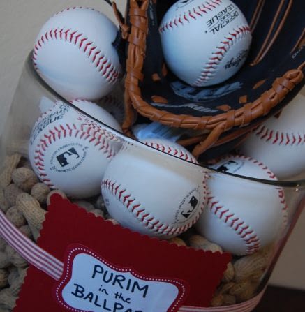 An easy Buffet Table center piece...A large glass cylinder vase, punch bowl, filled with peanuts. Then add baseballs, a baseball glove and another ball! You can either purchase baseballs from sports stores (if you know your boys will enjoy future use out of them!) or you can order fake cheaper ones from bulk stores like oriental trading. Even the squishy stress ball ones would work! I Wrapped a ribbon around it with a paper card in red and a label...keeping with my color scheme. You can add a box under the table linen to give it even more height if you wish. (If you are worried about Peanut allergy, try using popcorn or only baseballs).